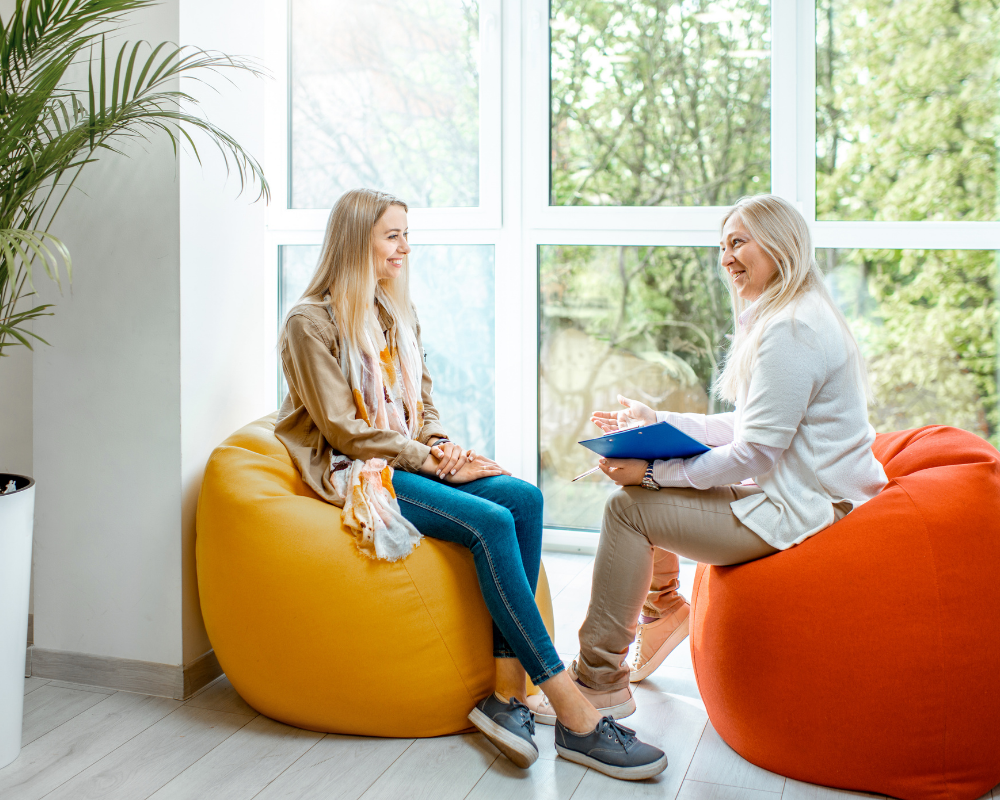 Two women on beanbags discussing