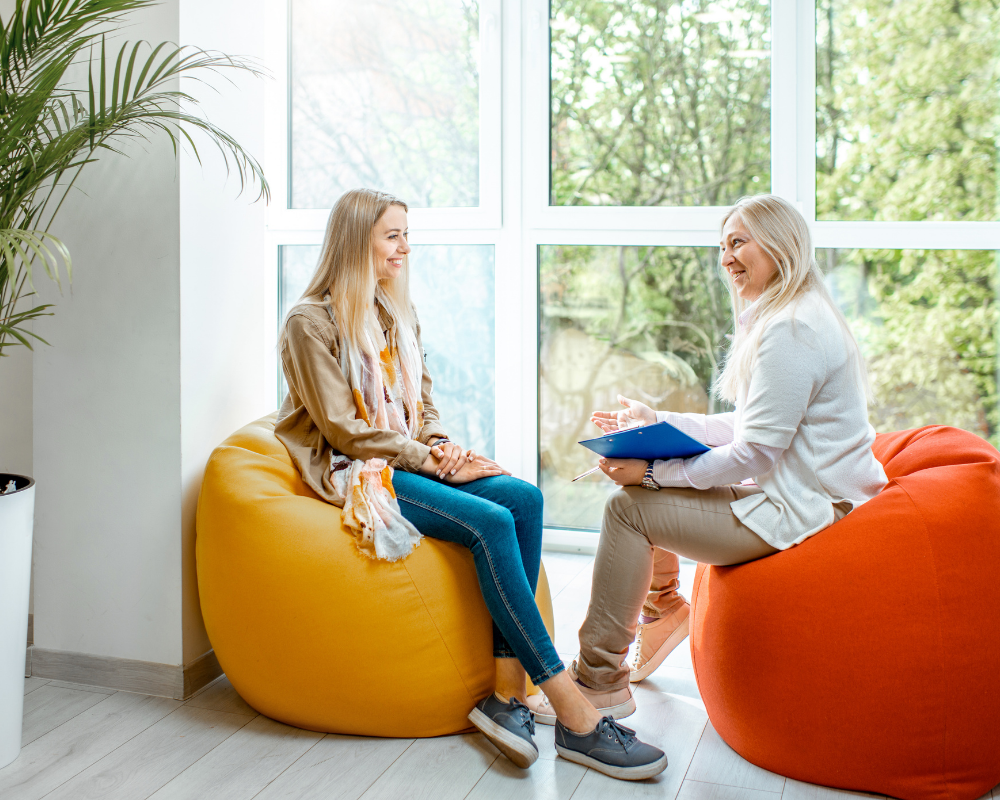 Two women on beanbags discussing 