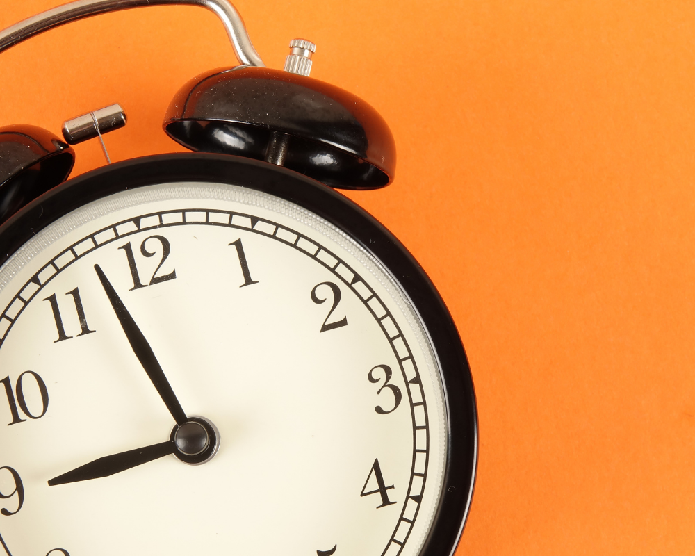 Alarm clock on orange background