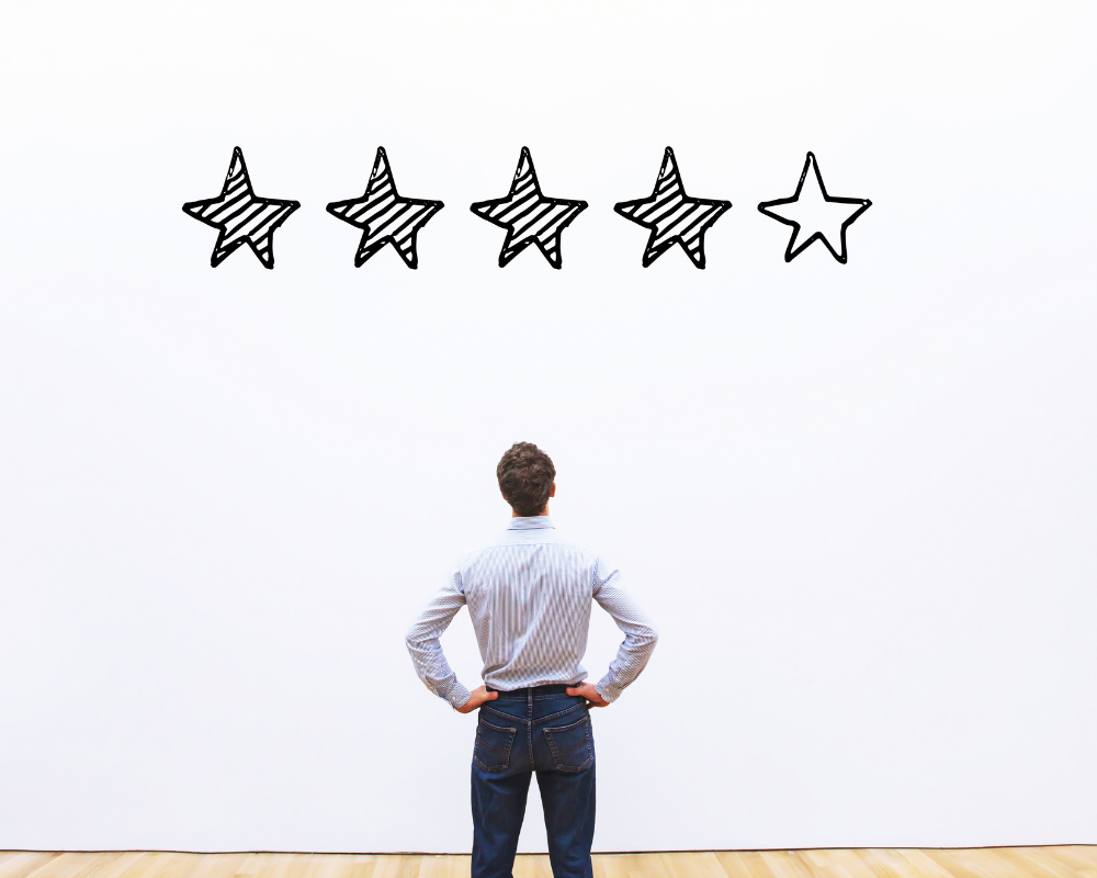Man looking at 4 star review on a white background.