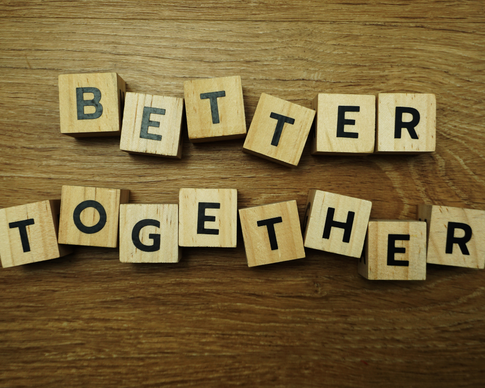 Wooden letter blocks spelling the word better together.