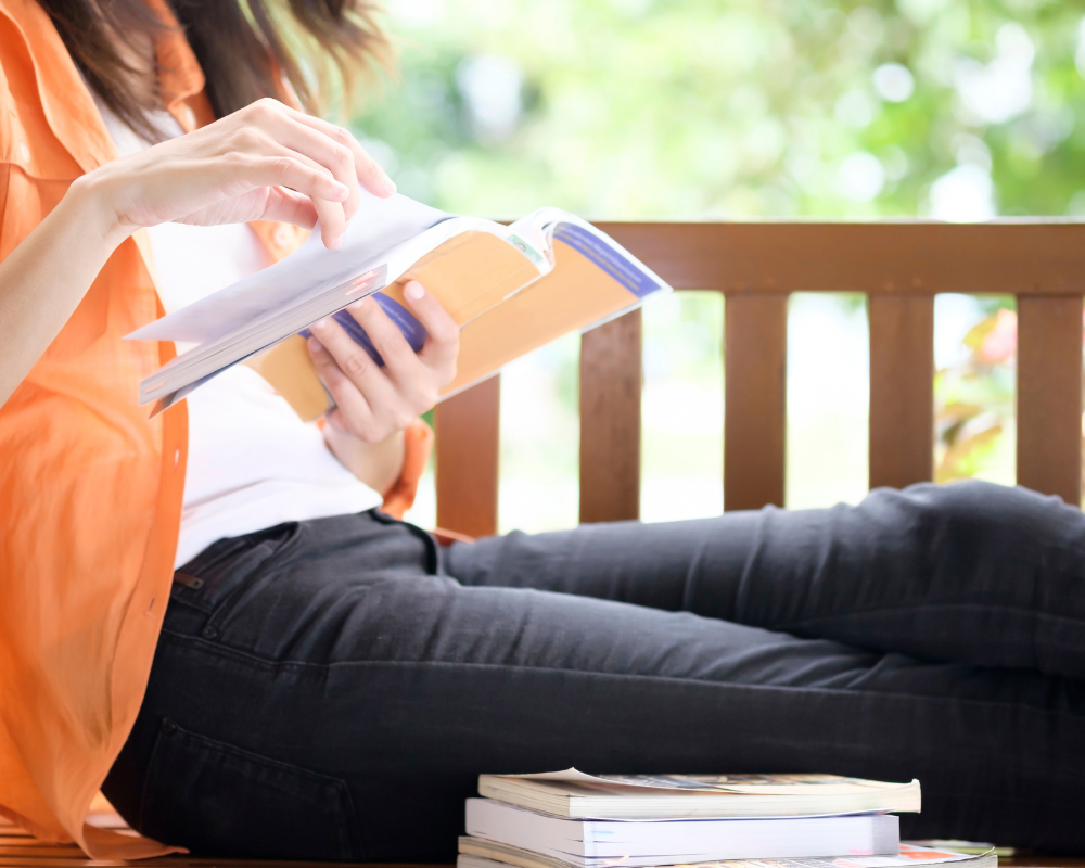 Professional reading a book outdoors, representing continuous learning and development in the medical sales industry.
