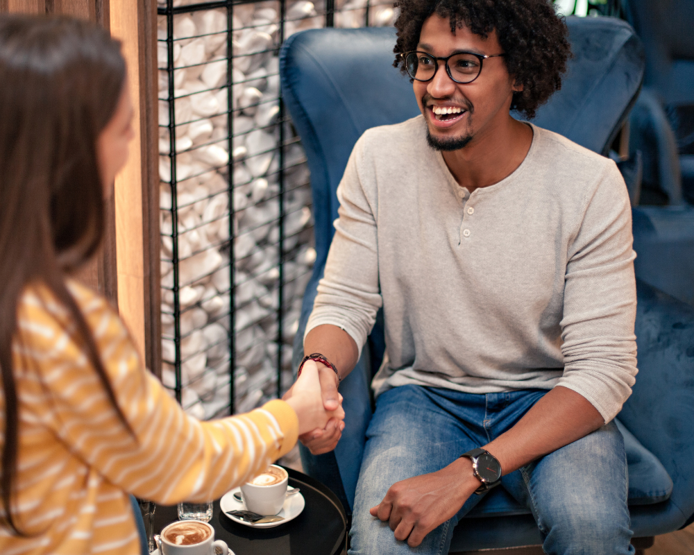 A man and woman chatting over coffee.