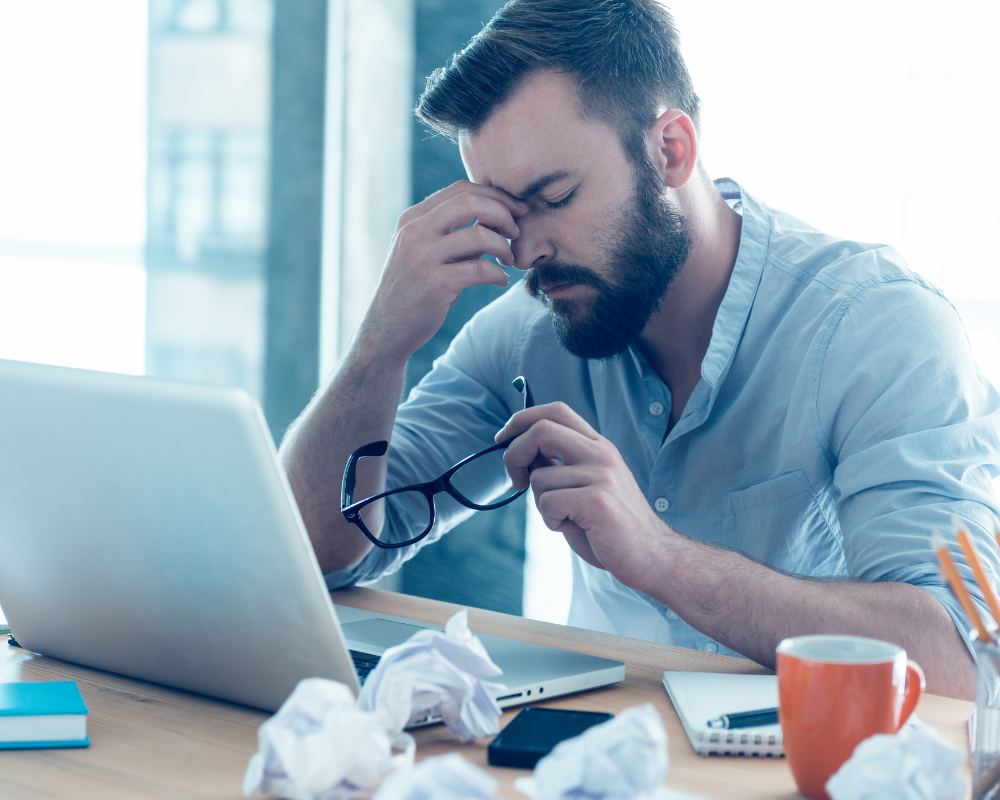 Man taking glasses off due to stress