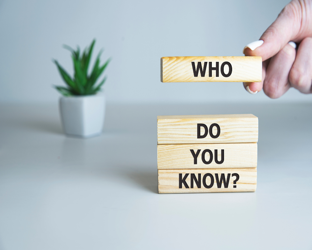 Wooden blocks stacked with the words ‘Who Do You Know?’ emphasizing the importance of networking