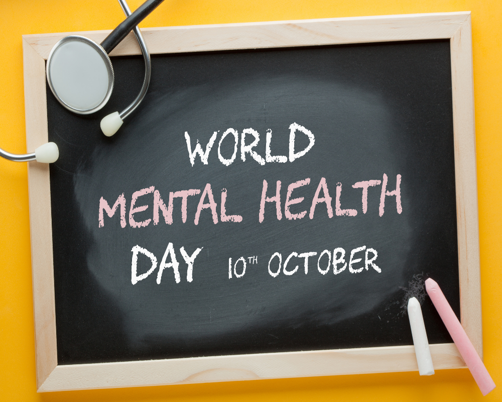 World mental health day is written on a chalkboard on an orange background.