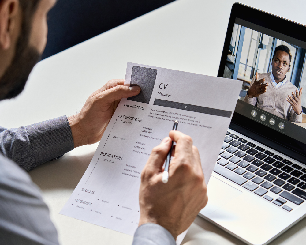 Man reading a CV during a virtual interview.